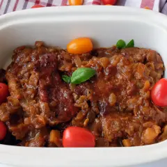 Karkówka w sosie własnym z pomidorami i bazylią, duszona w Coca-Coli. Pyszne danie gotowe do podania.