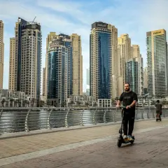 Mężczyzna na hulajnodze w Dubaju, wśród drapaczy chmur. Czy to początek afery dubajskiej?