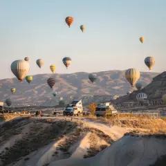 Balony unoszą się nad skalistym krajobrazem Kapadocji w Turcji, tworząc magiczny widok.