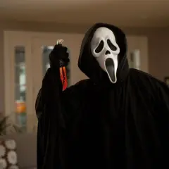 Postać w masce Ghostface z nożem, ikona najlepszych slasherów, czeka w mroku.