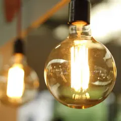 Żarówki Edisona świecą jasno, przypominając o rachunkach za prąd. Zastanawiasz się, ile kosztuje 1 kWh Enea?
