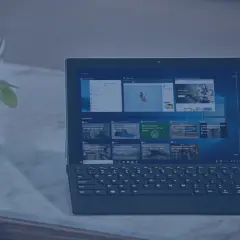 Nowoczesny laptop z klawiaturą i ekranem dotykowym, obok rośliny i stosu papierów. Idealny do pracy, gdy środek trwały od jakiej kwoty jest potrzebny.