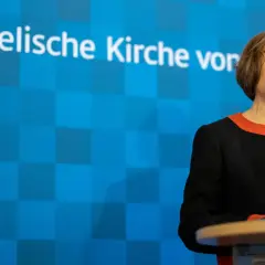 Die EKD-Vorsitzende spricht vor Mikrofonen. Im Hintergrund ist das Logo der Evangelischen Kirche von Westfalen zu sehen.