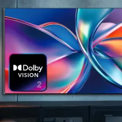 Osoba ogląda telewizor z logo Dolby Vision, wyświetlający abstrakcyjny, kolorowy obraz.