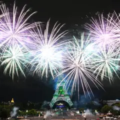 Spectaculaire feu d'artifice parisien illuminant la Tour Eiffel de mille feux. Des gerbes de lumière blanche et violette explosent dans le ciel nocturne.