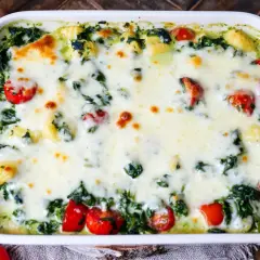 Gnocchi Spinat Auflauf mit geschmolzenem Käse und Kirschtomaten, ein köstliches Gericht, das zum Genießen einlädt.