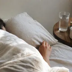 Una persona dorme avvolta nelle lenzuola, forse per sognare una vecchia fiamma. Sul comodino, un bicchiere d'acqua e dei libri.