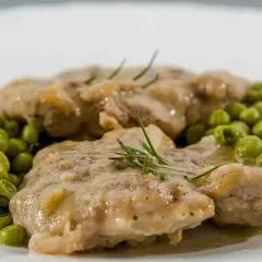 Ossobuco con piselli, un piatto succulento con carne tenera e piselli freschi, guarnito con rosmarino.