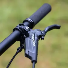 Close-up of a bicycle handlebar with a black brake lever. The lever has "KOO" branding, suggesting a brake fluid comparison.