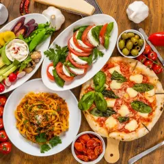Italienische Pasta Vorspeisen: Tagliatelle Bolognese, Pizza Margherita, Caprese-Salat, Gemüsesticks mit Dip und Oliven. Ein Festmahl!