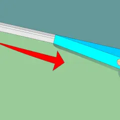 Applicazione di nastro adesivo blu per definire come fare bordo tra soffitto e parete. Freccia rossa indica la direzione.