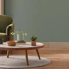 Gemütliches Wohnzimmer mit Sofa, Couchtisch und Pflanzen. Die Einrichtung ist in **neutralen Farben** gehalten, was eine beruhigende Atmosphäre schafft.