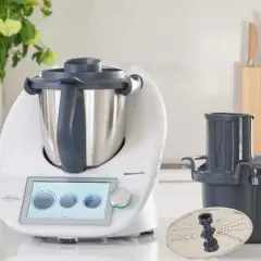 Biały Thermomix z ekranem dotykowym, akcesoriami i warzywami na blacie. Zastanawiasz się, ile wat ma Thermomix?