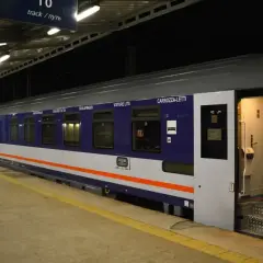 Nocny pociąg z otwartymi drzwiami wagonu sypialnego. Dowiedz się, jak kupić bilet na wagon sypialny i podróżować komfortowo.