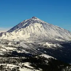 Schneebedeckter Teide-Vulkan auf Teneriffa im Dezember, ein beeindruckender Anblick über den Wolken.