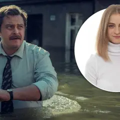 Mężczyzna w koszuli i krawacie brodzi w wodzie, obok uśmiechnięta kobieta w golfie. Wielka woda zalała miasto.