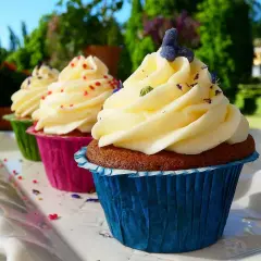 Tre cupcakes med fluffig frosting, dekorerade med strössel och lavendel. Perfekt frosting till cupcakes för en solig dag.