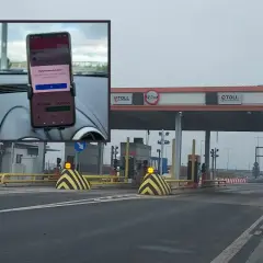 Telefon z aplikacją do opłat za autostradę A2 zamontowany w samochodzie przed bramkami e-TOLL.