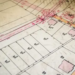 Stary plan geodezyjny z zaznaczonymi działkami ewidencyjnymi i budynkami.