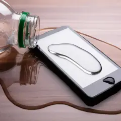 Telefon wpadł do wody, ale działa! Kropla wody na ekranie, a obok butelka.