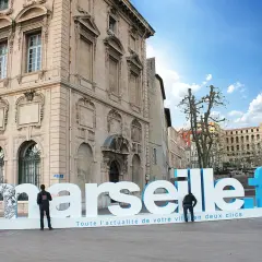 Une lettre géante extérieur "Marseille.fr" trône sur une place, invitant à découvrir l'actualité de la ville.