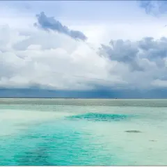 Malediwy w porze deszczowej: turkusowa woda i burzowe chmury nad oceanem.