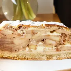 Pyszny kawałek szarlotki z warstwami jabłek i kremu, posypany cukrem pudrem. Idealny, by dowiedzieć się, ile piec szarlotkę.