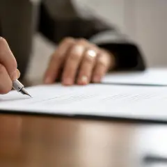 Mano firmando un contrato de arras modelo con pluma estilográfica.