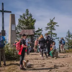 Grupa turystów na szczycie Turbacz (1310 m n.p.m.). Zastanawiają się, ile jeszcze idzie się do celu.