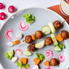 Vegetarisk mat för barn: Spett med vegetariska köttbullar, gurka, morötter och rädisor. En festlig och färgglad måltid.