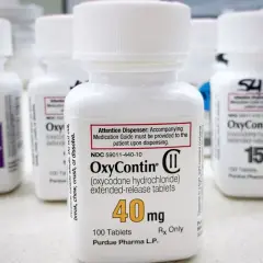 Butelki leku OxyContin, w tym jedna z dawką 40 mg, stoją na blacie.
