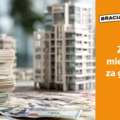 Stosy pieniędzy i makieta budynku. Kredyt hipoteczny dla firm może pomóc w zakupie mieszkania za gotówkę.