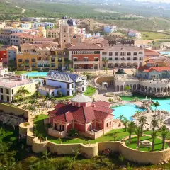 Vista aérea del hotel Villaitana en Benidorm, con sus coloridos edificios, piscinas y exuberante vegetación.