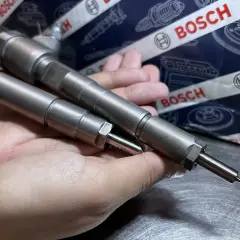 Dwie wtryskiwacze Bosch w dłoni, gotowe do montażu. Ich precyzja zapewnia samoadaptację wtryskiwaczy dla optymalnej pracy silnika.