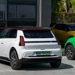 Nowy Renault 5 w białym kolorze, obok zielonego i żółtego, prezentuje się nowocześnie.