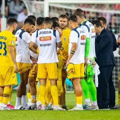 Piłkarze Rumunii w żółtych strojach, w tym Sorișcu (23) i Stanciu (10), zebrani na boisku. Może to być mecz z Ukrainą.