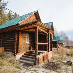 Solidny fundament pod domek letniskowy z bali, z zielonym dachem i drewnianą werandą.