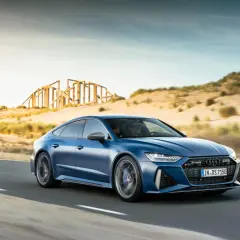Niebieskie Audi RS7 mknie po pustynnej drodze. Sprawdź aktualną audi rs7 cena i poczuj moc!