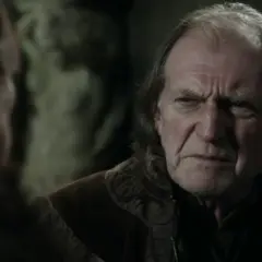 David Bradley w filmach i serialach, z charakterystycznym zmarszczonym czołem, w rozmowie z kimś.