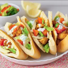 Cinco deliciosos panes de pita rellenos de pollo crujiente, lechuga, tomate y aderezo cremoso.
