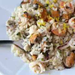 Un délicieux risotto fruits de mer crémeux, garni de crevettes, moules et calamars, avec une touche de zeste de citron.