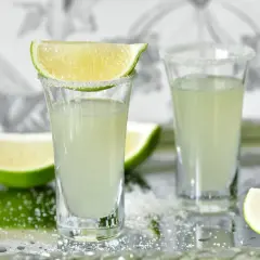 Dwa kieliszki z drinkiem Kamikaze, ozdobione cukrem i limonką. Zastanawiasz się, kamikaze drink ile procent?