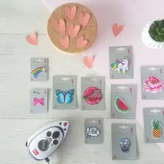 Un fer à repasser et divers patchs thermocollants : étoile filante, papillon, basket, pastèque, licorne, fleur, ananas, crâne, et bulle "Je rêve". Idéal pour créer un patch thermocollant personnalisé.