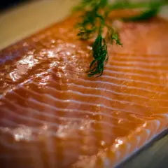 Świeży kawałek łososia z gałązką koperku. Zastanawiasz się, ile kcal ma łosoś? To zdrowe i pyszne danie.