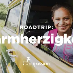 Ein lächelndes Mädchen im Auto, bereit für einen Roadtrip der Barmherzigkeit, inspiriert von Lukas 10, 25-37.