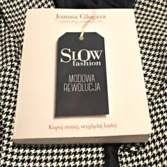 Książka "Slow fashion. Modowa rewolucja" Joanny Glogazy na tle wzorzystej tkaniny. Inspiracja dla polskich marek slow fashion.