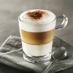 Idealne latte macchiato proporcje: mleko, espresso i pianka tworzą apetyczne warstwy. Posypane kakao.