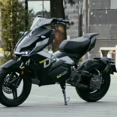 Moderna repro moto 125 eléctrica, negra y futurista, aparcada en la calle.