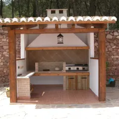 Barbacoa de obra con estructura de madera y tejado de tejas. Ideal para aprender como hacer una barbacoa de obra y disfrutar del exterior.