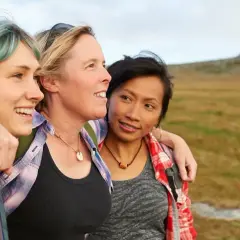 Drei Freundinnen genießen die Natur. Ihre Freundschaft zeigt sich in der Nähe und dem Lachen.